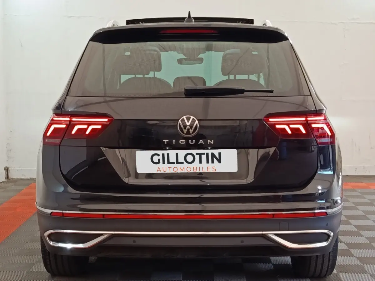 Vue arrière d’un Volkswagen Tiguan noir 2021 avec feux LED allumés et logo VW bien visible.