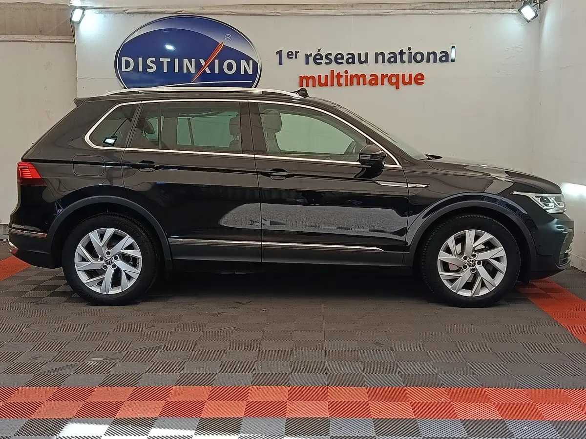 Volkswagen Tiguan 2.0 TDI 150 DSG7 Elegance noir vu de profil côté gauche en intérieur showroom.