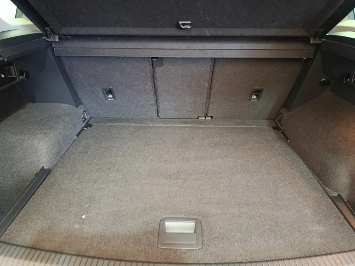Coffre spacieux du Volkswagen Tiguan 2.0 TDI 150 DSG7 Elegance, vue intérieure arrière avec revêtement gris.