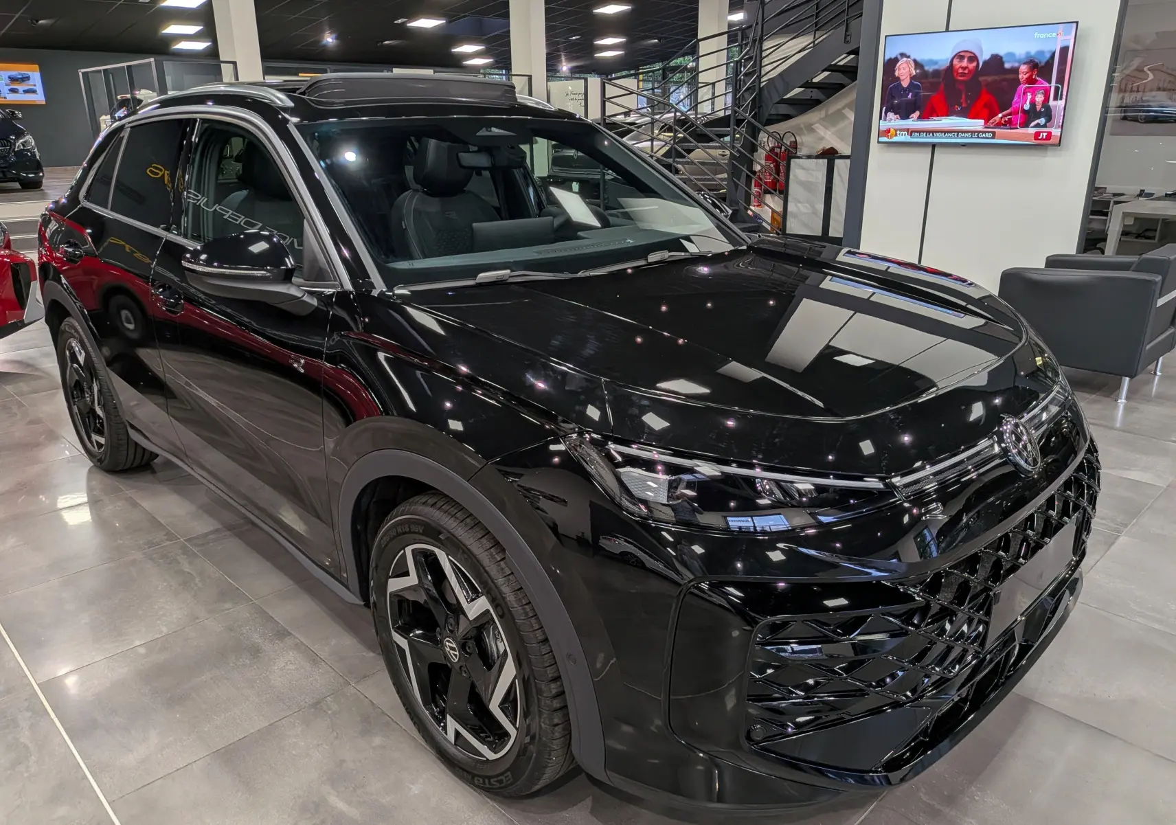 Volkswagen T-Roc eTSI noir Ébène en 3/4 avant droit, avec jantes biton et calandre R-Line distinctive.