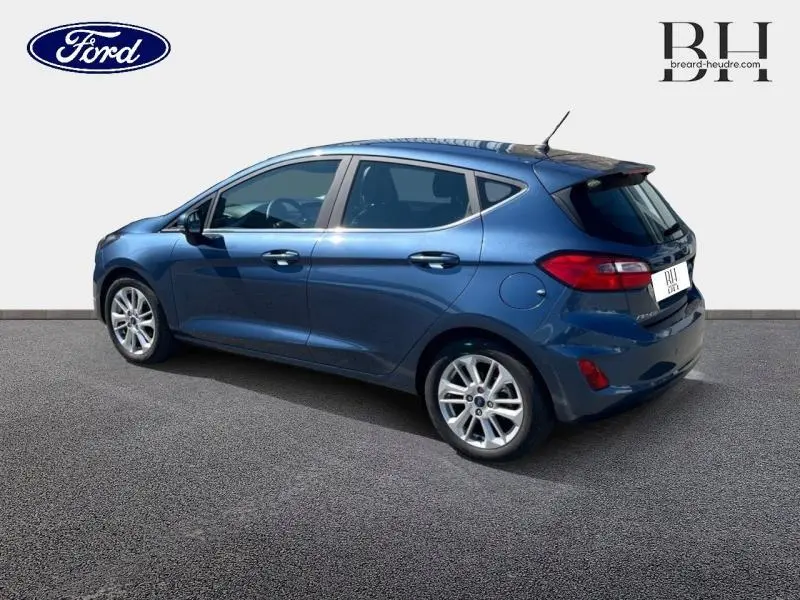 Ford Fiesta 2022 bleu azur métallisé vue 3/4 arrière côté gauche avec jantes alliage et becquet arrière