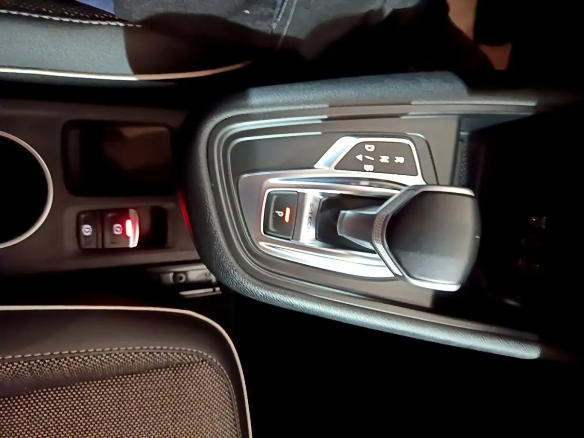 Gros plan sur la console centrale noire du Renault Captur Intens E-Tech 2021, montrant le levier de vitesse automatique et frein à main électrique.