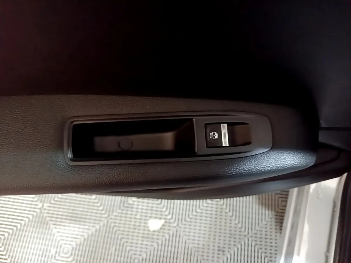 Détail de la commande de lève-vitre électrique côté conducteur sur porte intérieure noire d’un Renault Captur.