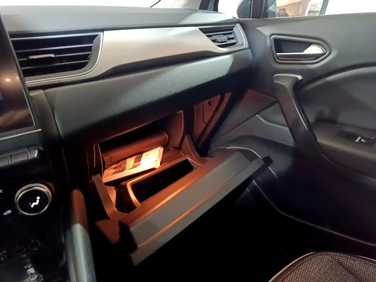 Intérieur Renault Captur Intens E-Tech 2021, vue côté passager sur boîte à gants ouverte et tableau de bord noir.