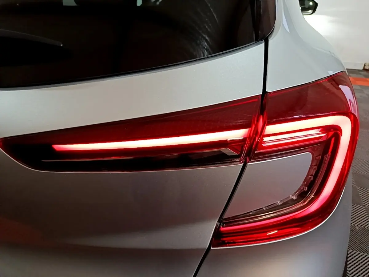Gros plan sur le feu arrière droit rouge allumé du Renault Captur Intens E-Tech hybride gris clair de 2021.