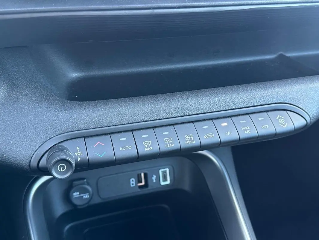 Vue rapprochée de la console centrale noire du Jeep Avenger 2025 montrant les commandes climatisation et ports USB.