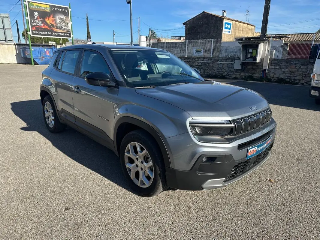 Jeep Avenger gris en 3/4 avant droit, avec jantes alliage 17 pouces et calandre distinctive à sept fentes.