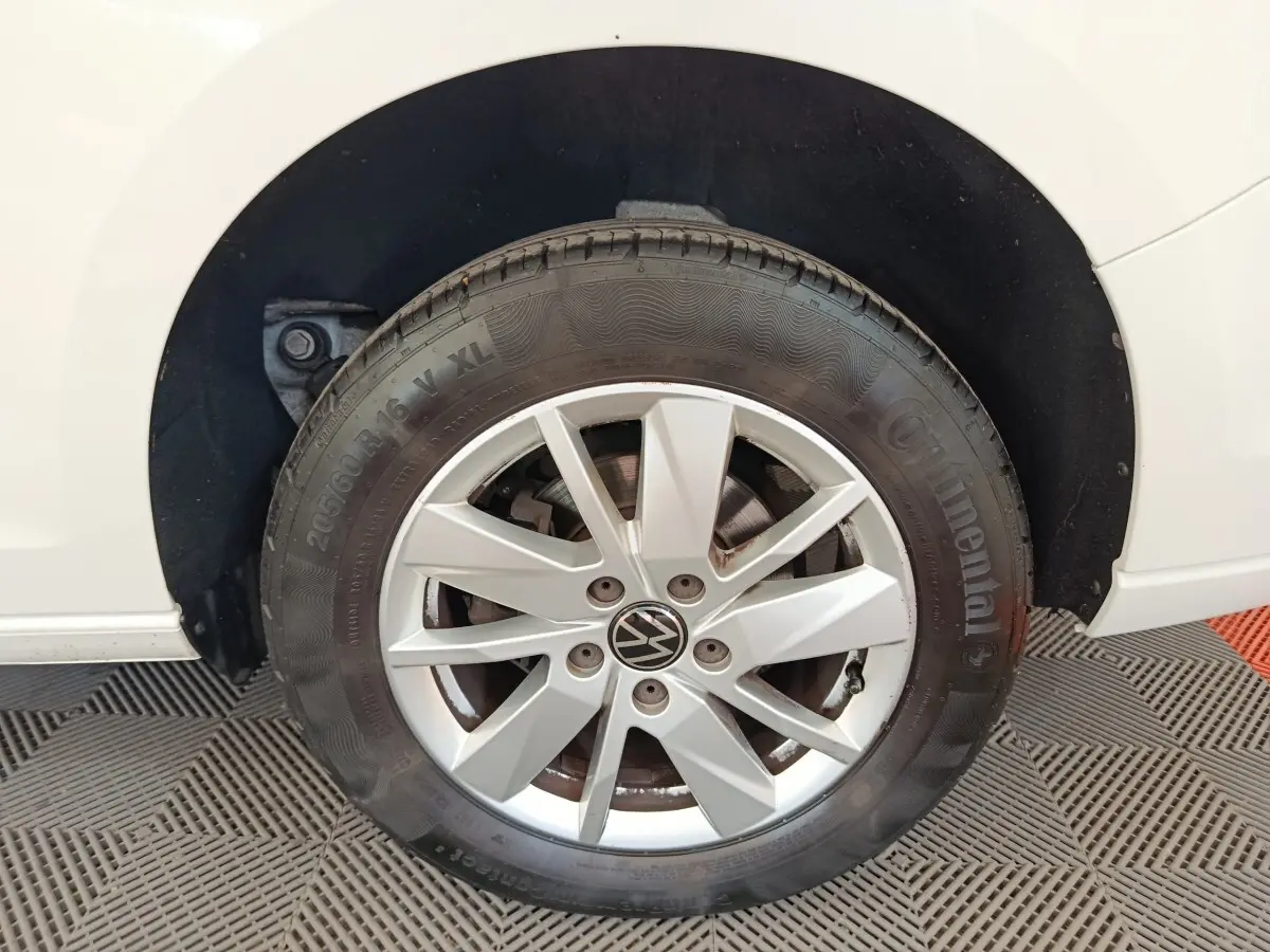 Gros plan sur la roue avant droite blanche d’un Volkswagen Caddy 2.0 TDI 122ch avec jante en alliage et pneu Continental.