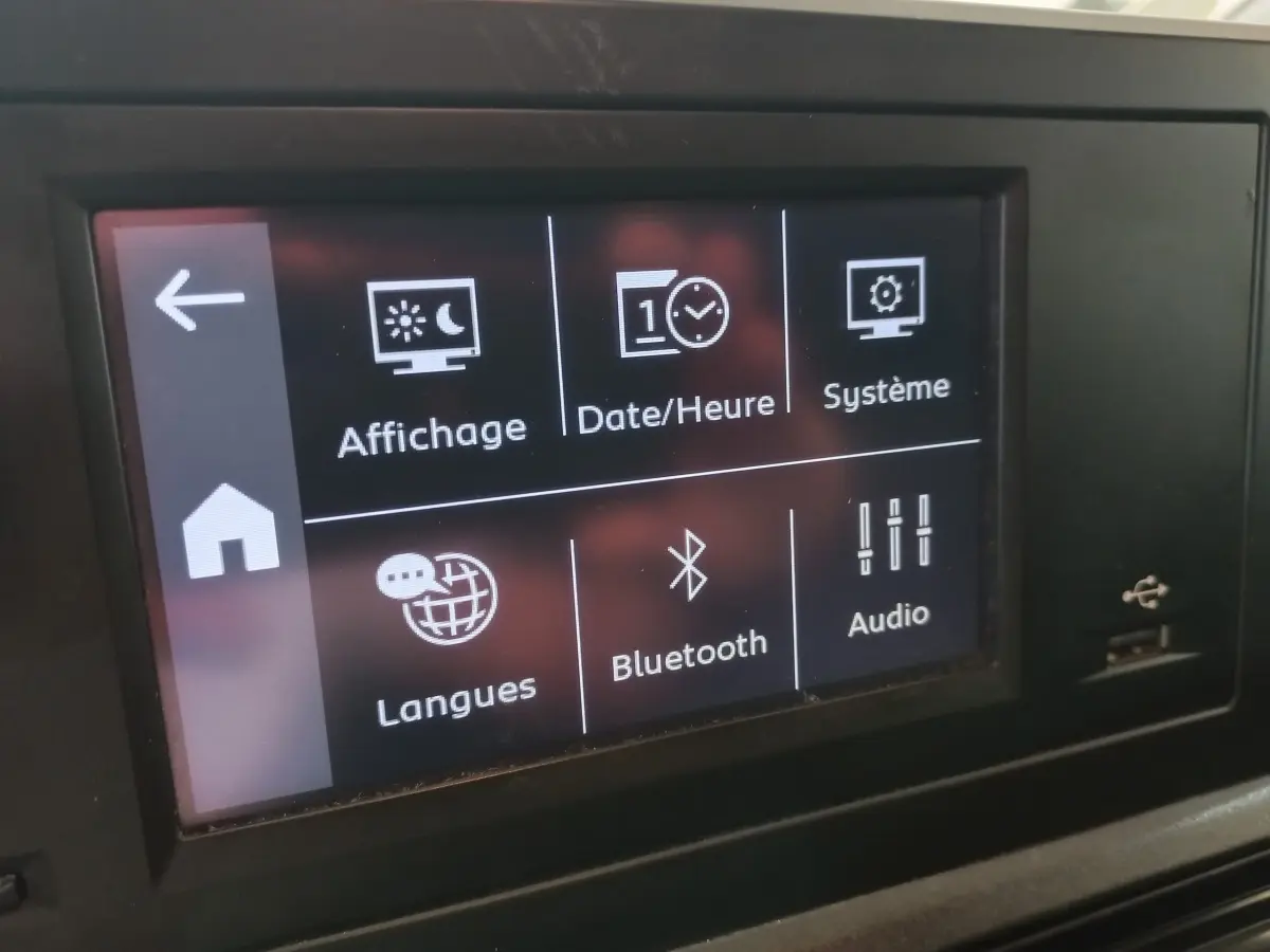 Écran tactile central du Peugeot Partner blanc, affichant les options de réglages Bluetooth et audio.