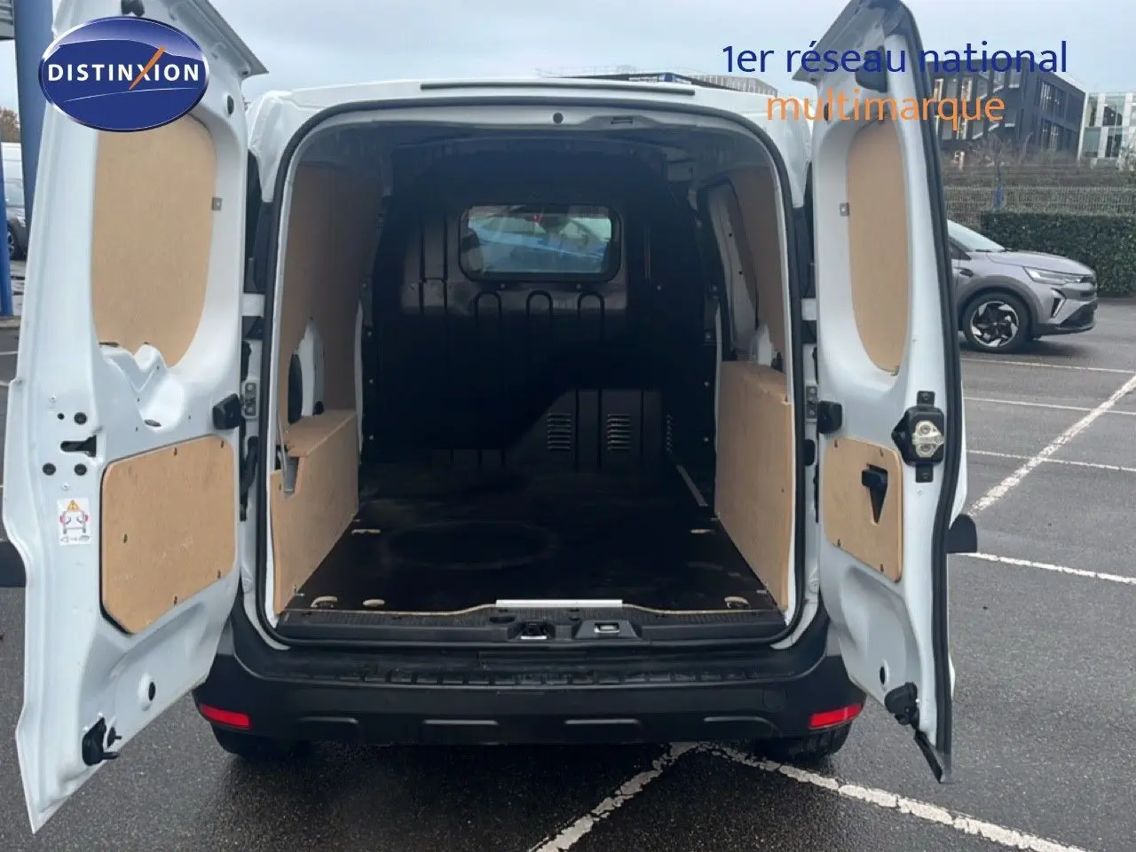 Vue arrière du Renault Express Van blanc glacier 2023 avec portes ouvertes dévoilant l'espace de chargement vide et protégé.