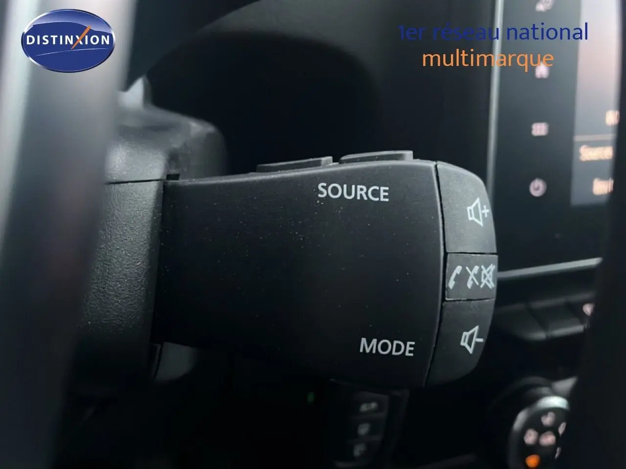 Gros plan sur la commande au volant du Renault Express Van blanc glacier, avec boutons source et mode visibles.
