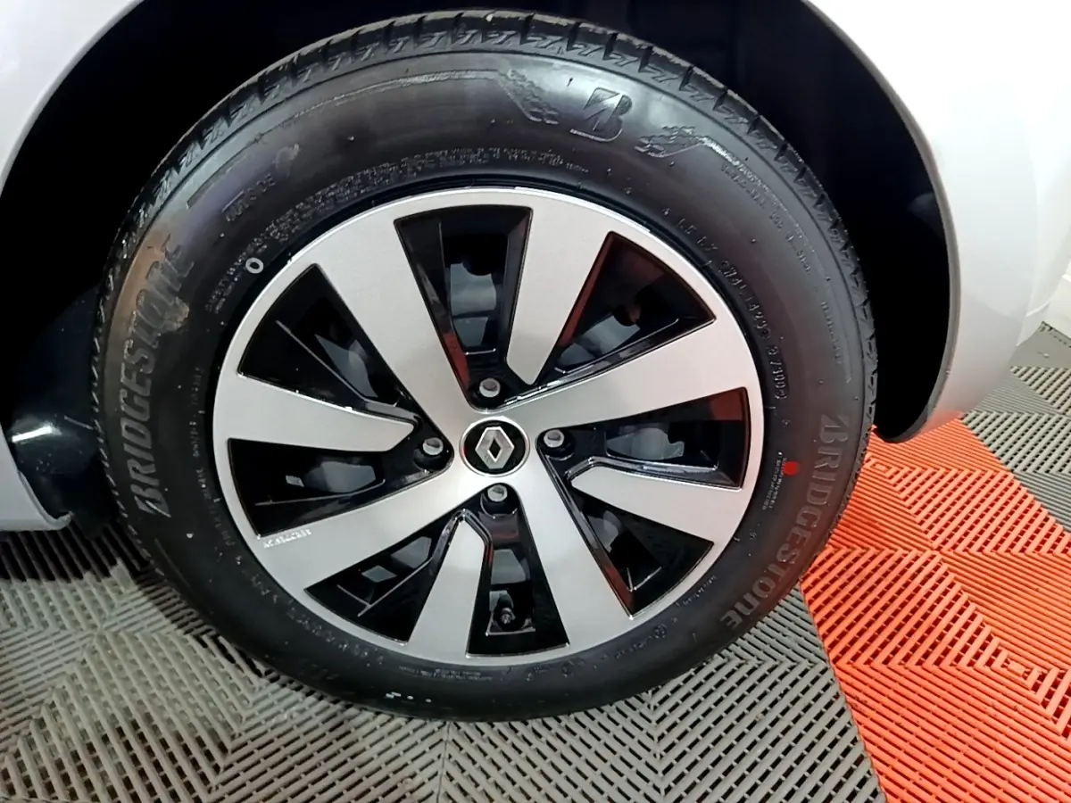 Gros plan sur la roue avant droite de la Renault Clio gris clair 2023 avec jante alliage bicolore et pneu Bridgestone.