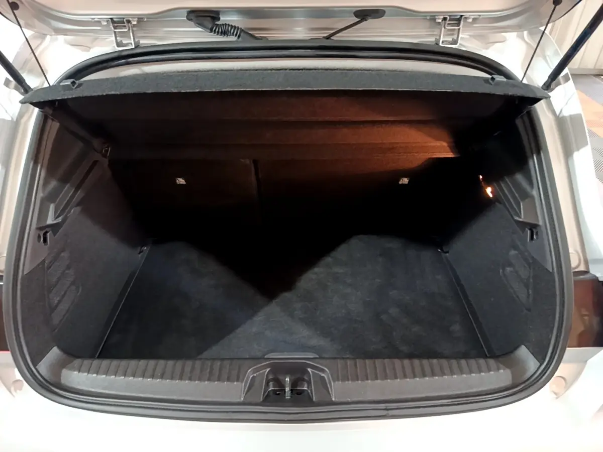 Coffre ouvert vu de l'arrière d'une Renault Clio gris clair 2023, espace de chargement vide et propre.