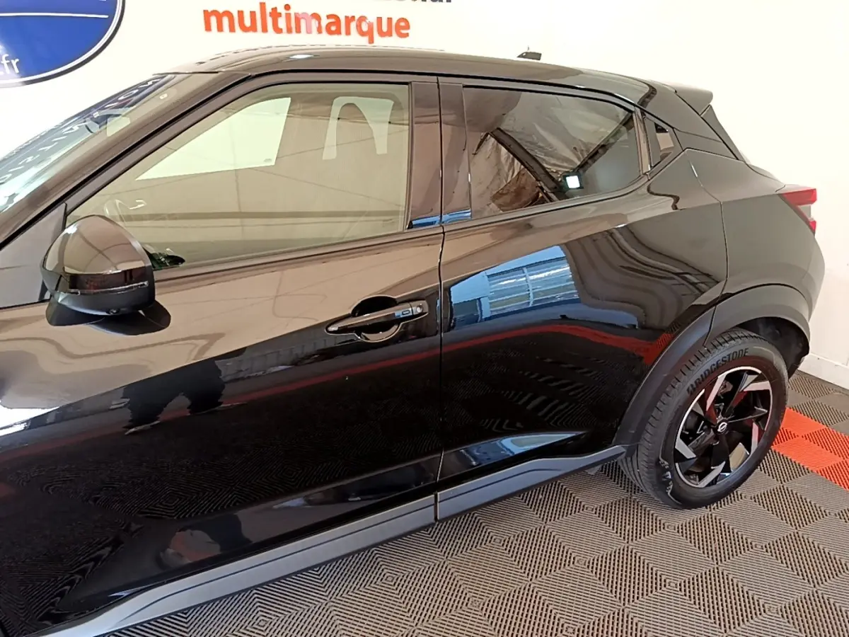 Vue latérale côté droit du Nissan Juke noir 2022 avec jantes noires et rétroviseurs ton caisse.