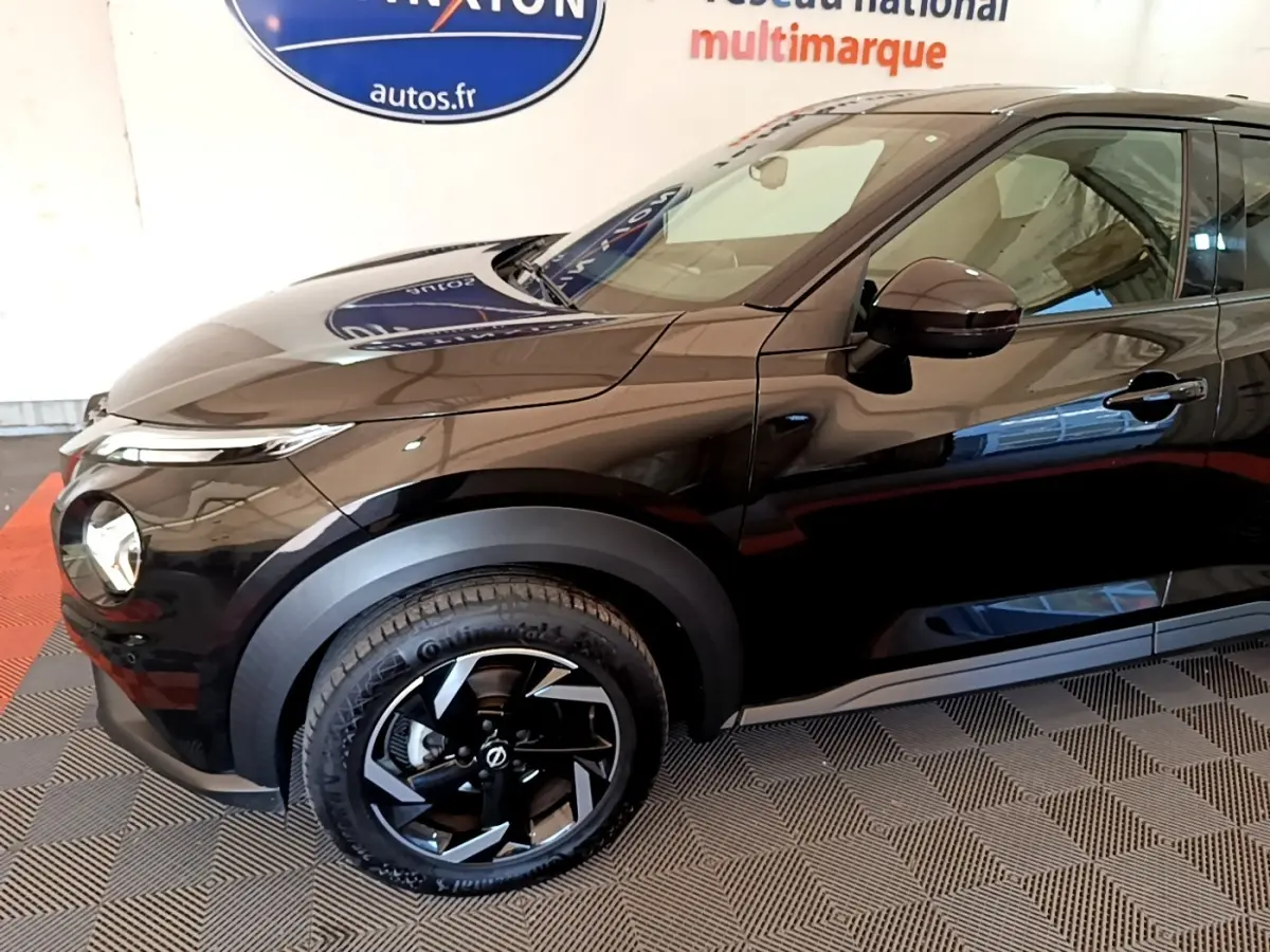 Vue de profil côté gauche du Nissan Juke DIG-T 114 DCT noir, mettant en valeur la roue avant et les rétroviseurs ton caisse.