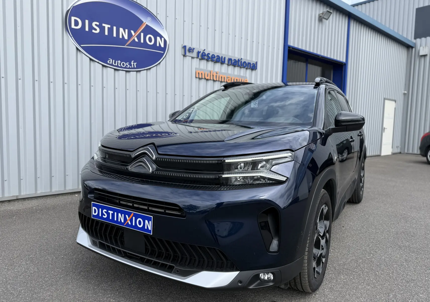 Vue 3/4 avant droit du Citroën C5 Aircross Hybrid 145 e-DSC6 Max bleu foncé, avec calandre distinctive et phares LED.