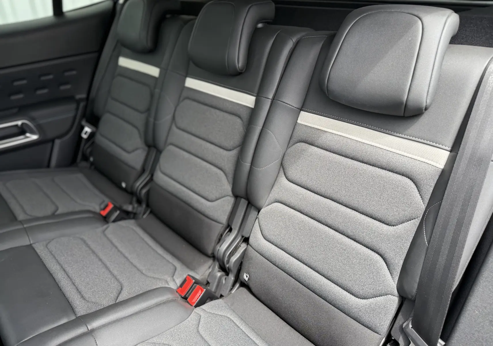 Vue rapprochée des sièges arrière gris foncé du Citroën C5 Aircross Hybrid 145 e-DSC6 Max avec appuie-têtes intégrés.