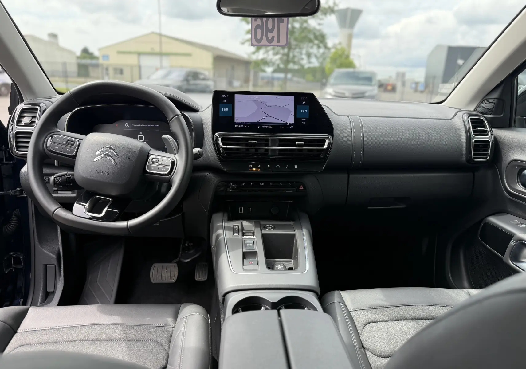 Vue intérieure avant du Citroën C5 Aircross Hybrid 145, tableau de bord moderne avec écran tactile et volant multifonction.