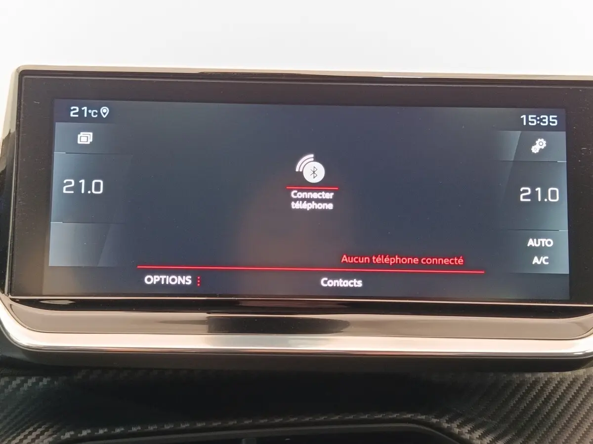 Écran tactile central affichant la connexion Bluetooth dans l’habitacle d’une Peugeot 208 blanche, vue de face.