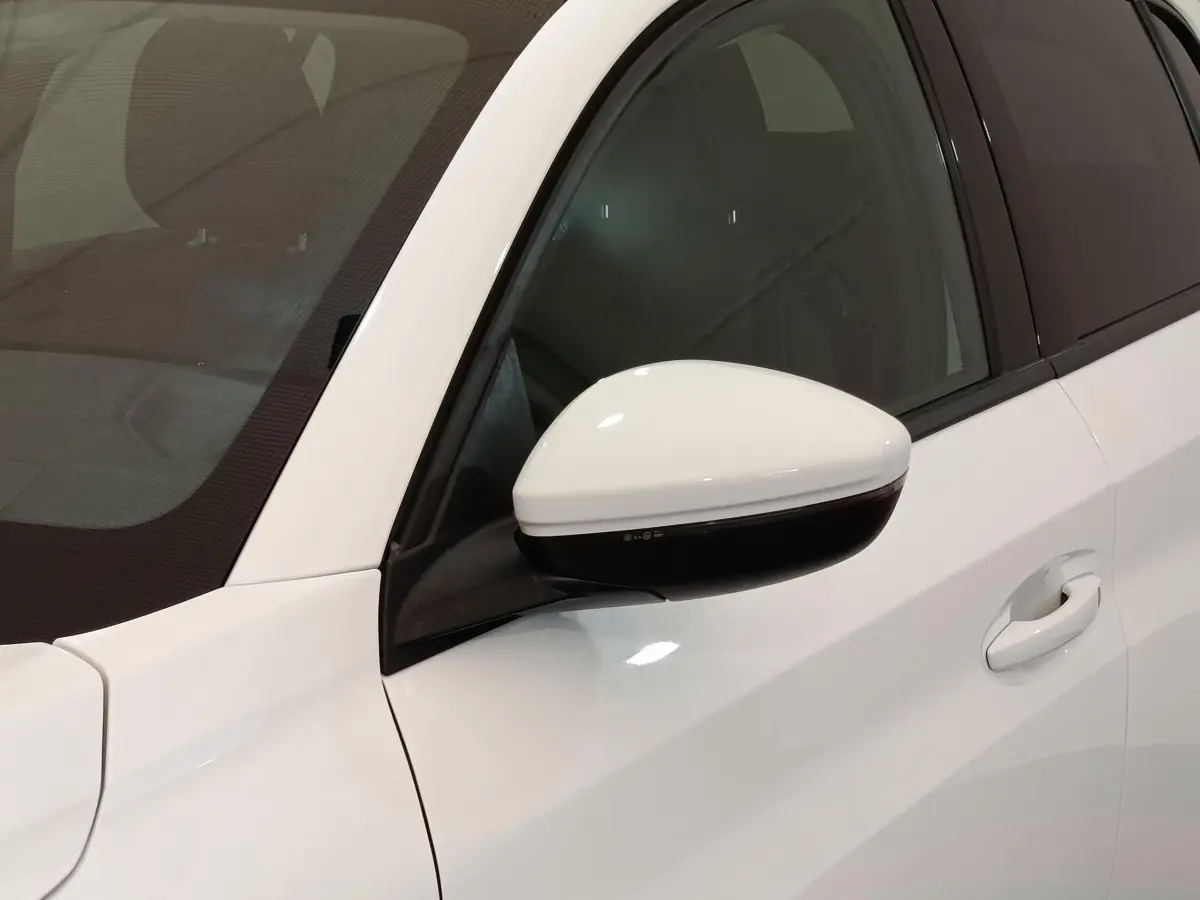 Détail du rétroviseur blanc côté gauche d’une Peugeot 208 PureTech 100 S&S Allure Business 2021.