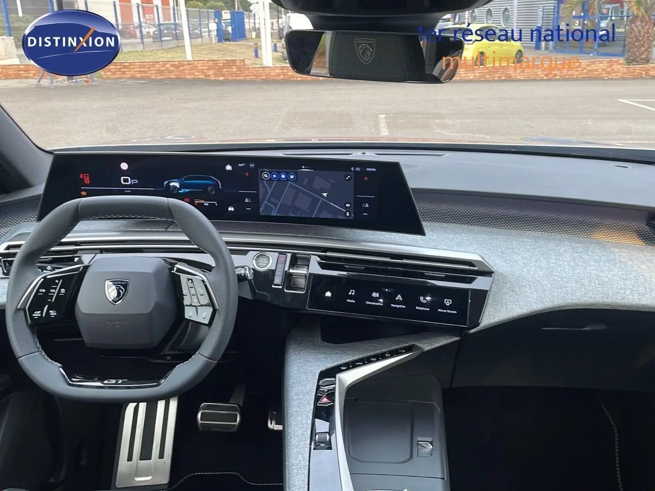 Intérieur moderne du Peugeot 5008 Hybrid 136ch GT 2025, vue du tableau de bord avec écran large et volant compact noir.