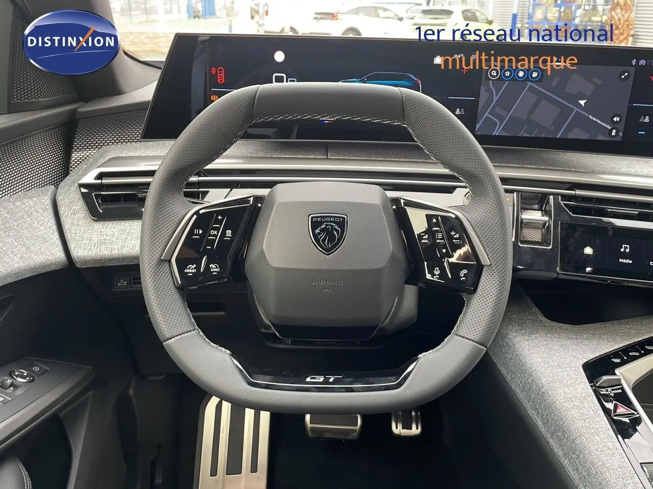 Volant GT en cuir noir perforé du Peugeot 5008 Hybrid 2025 avec tableau de bord numérique et commandes intégrées.
