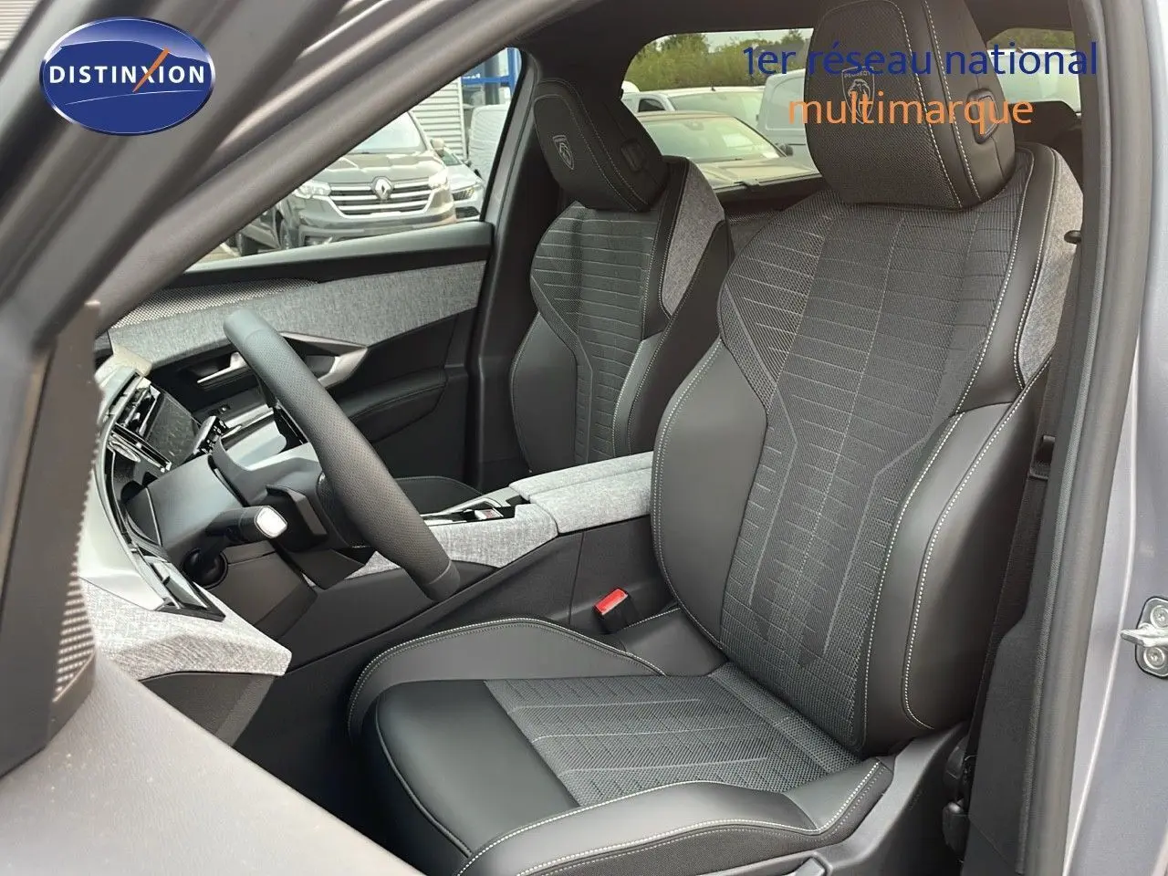 Intérieur avant droit du Peugeot 5008 Hybrid 136ch GT 2025 avec sièges cuir et tissu gris, volant multifonction visible.