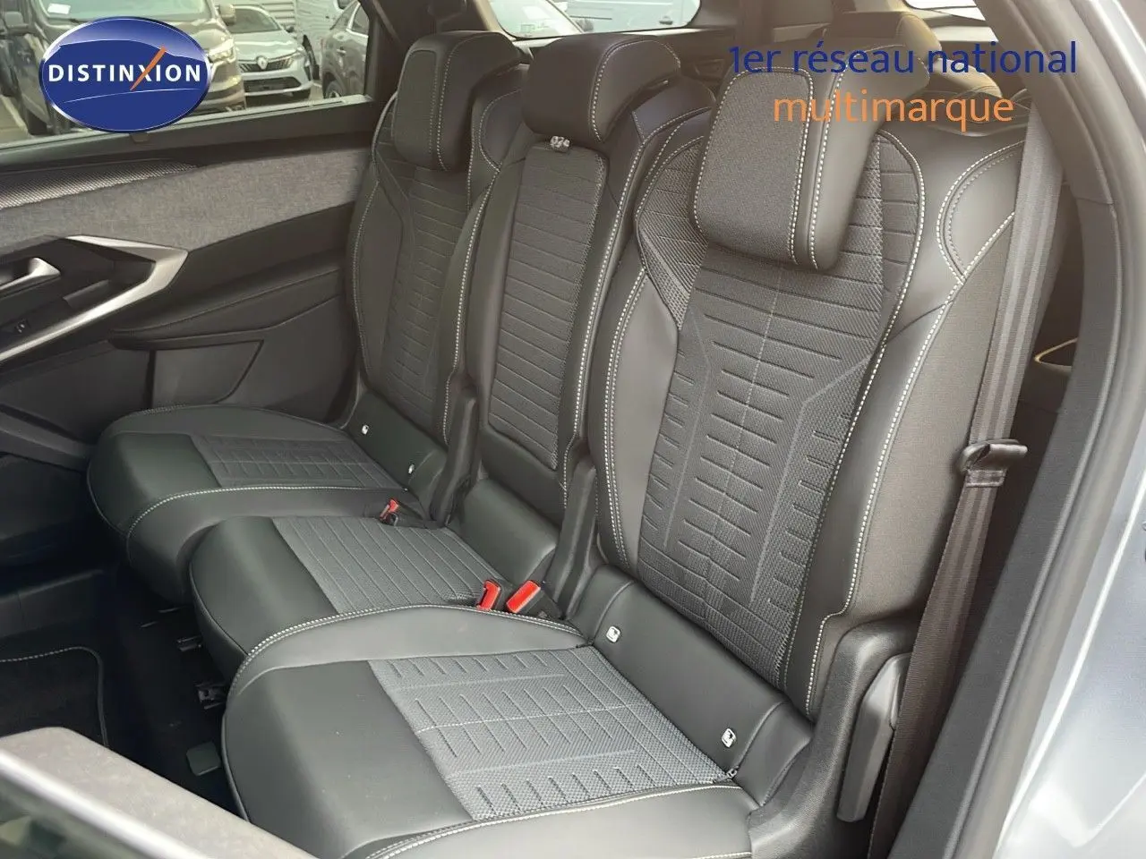 Vue intérieure côté droit des sièges arrière en cuir noir et tissu gris du Peugeot 5008 Hybrid 2025 avec surpiqûres contrastées.