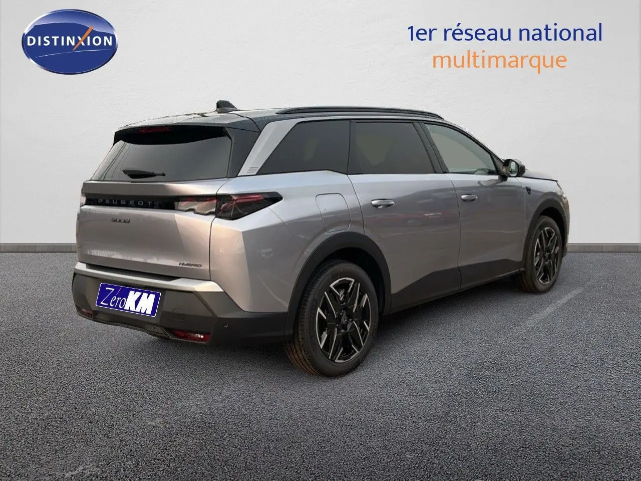 Peugeot 5008 Hybrid gris Artense métal avec toit noir, vue 3/4 arrière côté droit sur sol gris.