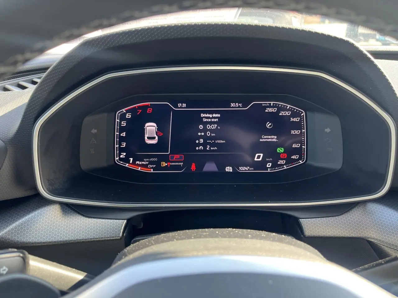 Vue rapprochée du tableau de bord numérique de la SEAT LEON IV gris Magnetic, affichant les données de conduite et la vitesse.