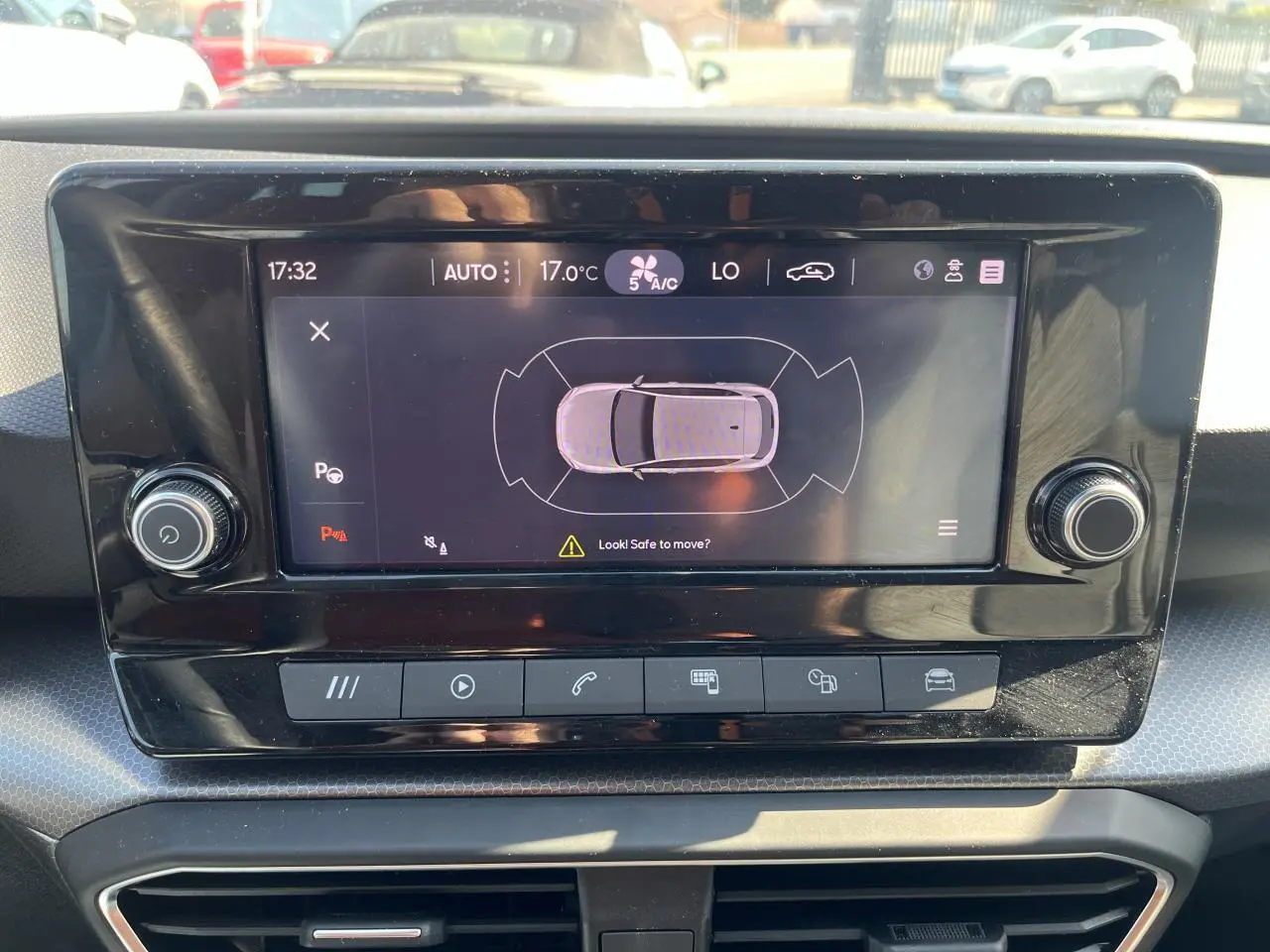 Écran tactile central du tableau de bord du SEAT Leon IV 2023 affichant l'aide au stationnement en vue aérienne.