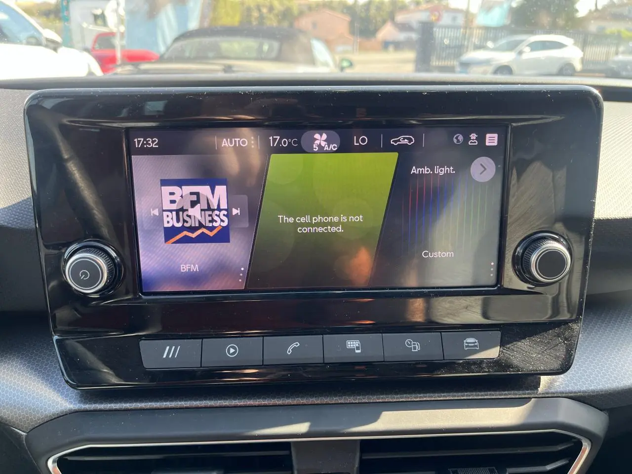 Écran central tactile du tableau de bord de la SEAT Leon IV 2023 affichant la radio BFM Business et les réglages climatiques.