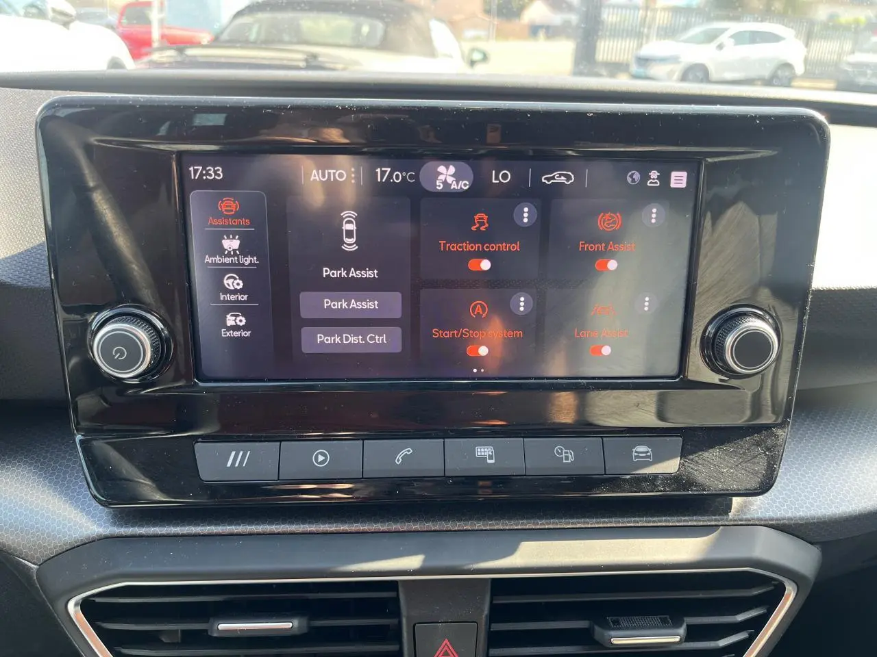 Écran tactile central du tableau de bord du SEAT Leon IV gris, affichant les options d'assistance à la conduite.