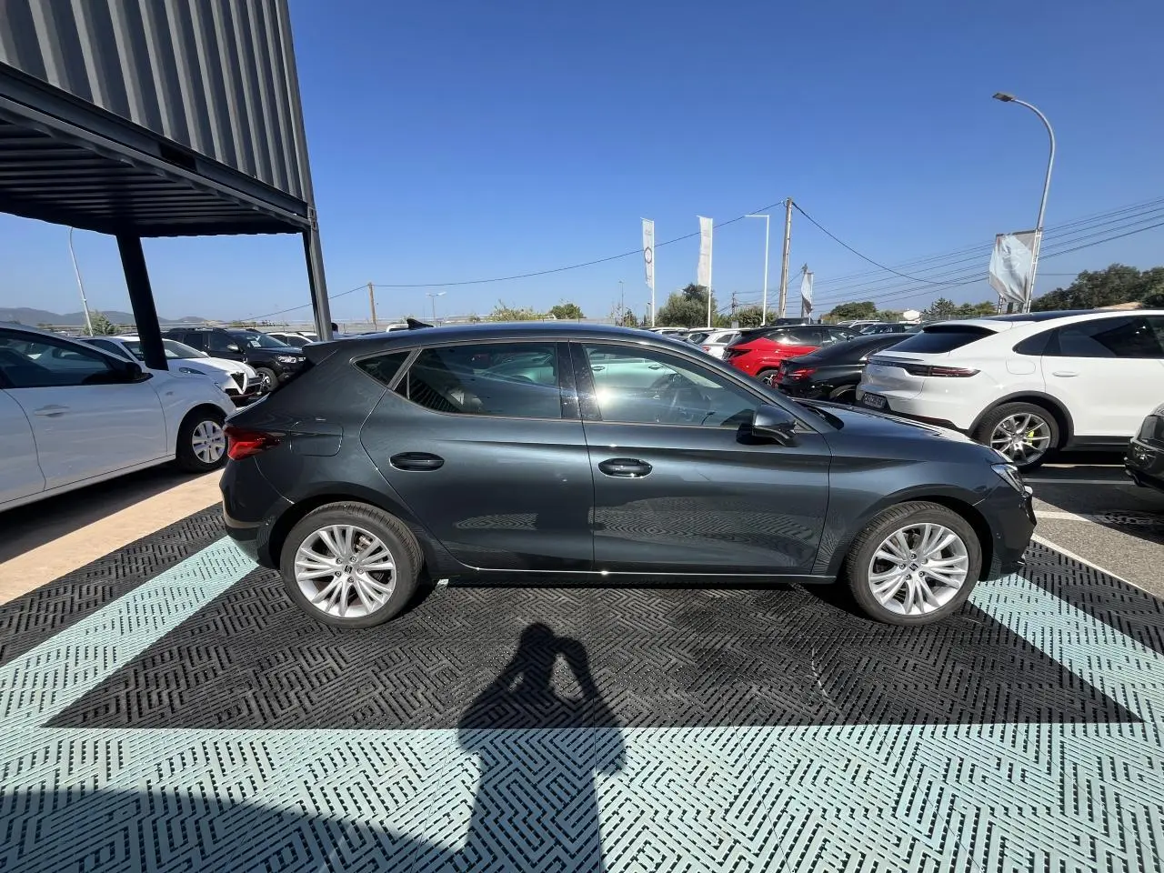 Vue latérale droite d'une SEAT LEON IV 1.5 ETSI 150 Gris Magnetic Metal, garée en extérieur au soleil.