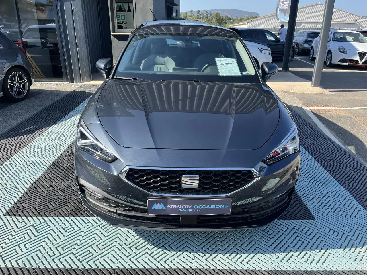 Vue frontale d'une SEAT LEON IV 1.5 ETSI 150 Speciale Edition gris magnetic metal avec calandre hexagonale et phares LED.