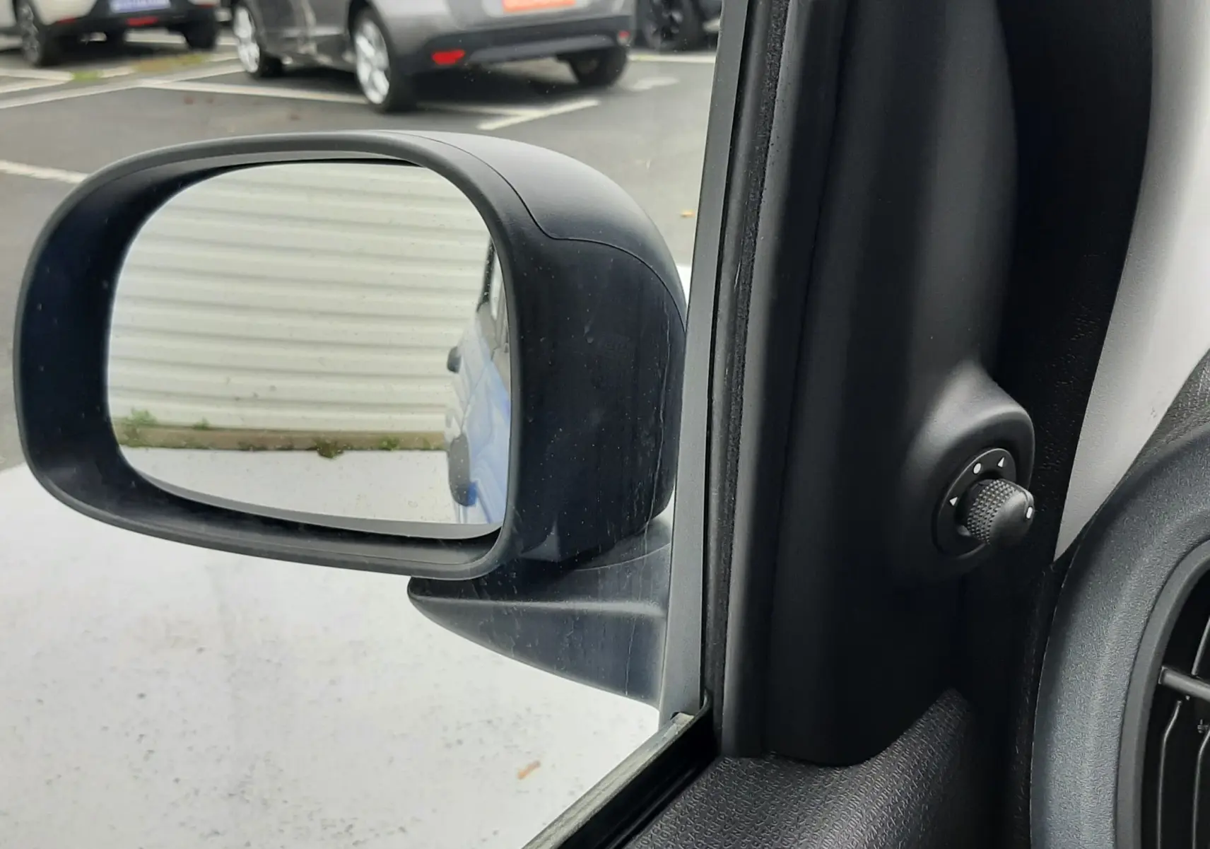 Rétroviseur côté gauche d'une Fiat Panda blanc gelato, avec commande de réglage manuel visible à l'intérieur.