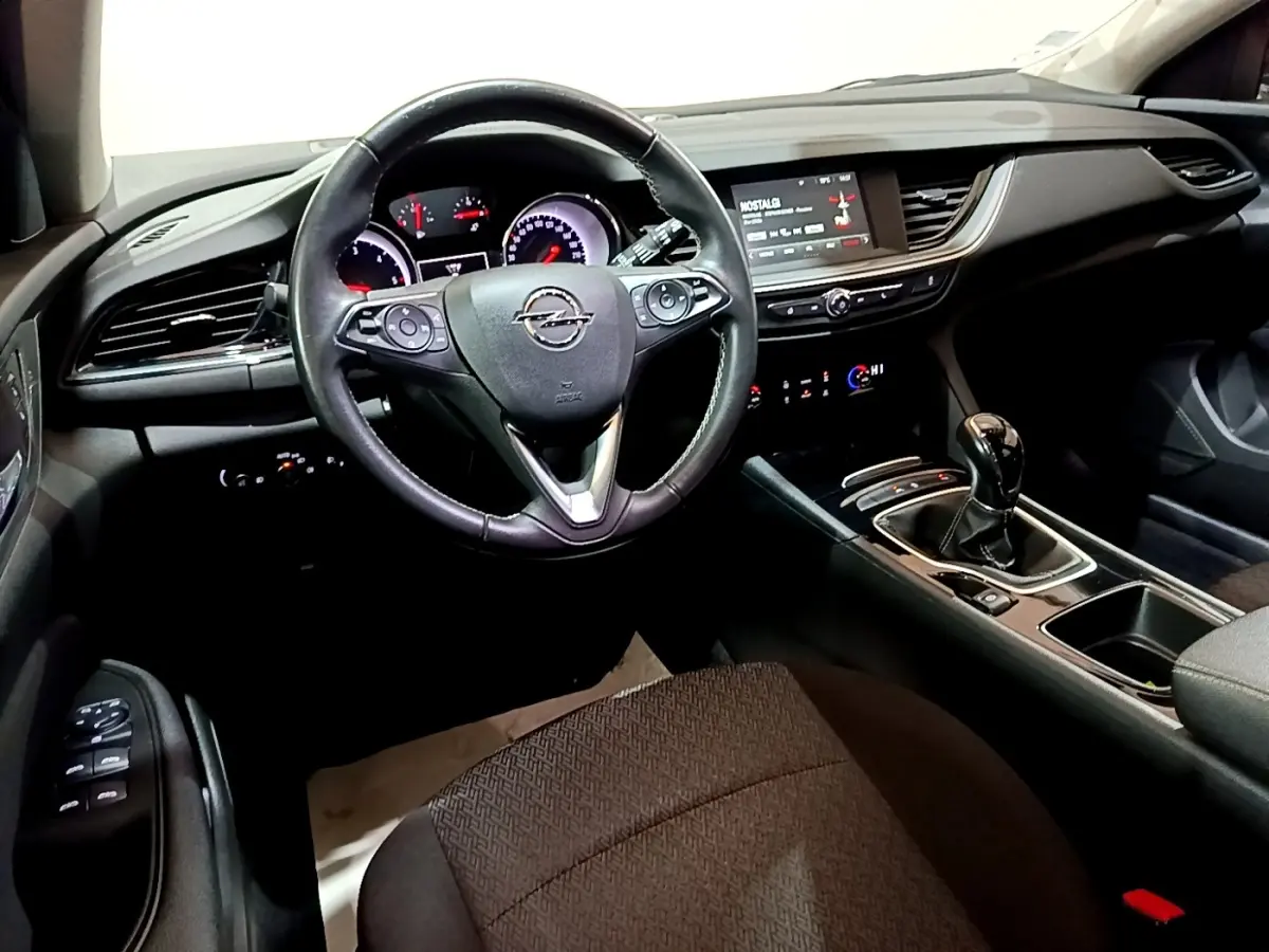 Vue intérieure de face du poste de conduite de l'Opel Insignia 2019 avec volant cuir noir et tableau de bord digital.