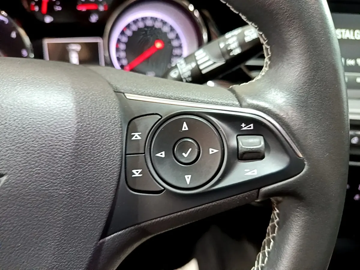 Gros plan sur les commandes du volant en cuir noir de l’Opel Insignia 2019, version Edition Business.