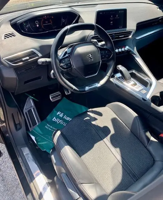 Intérieur du Peugeot 3008 2018 noir, vue côté conducteur sur le volant, tableau de bord numérique et console centrale moderne.