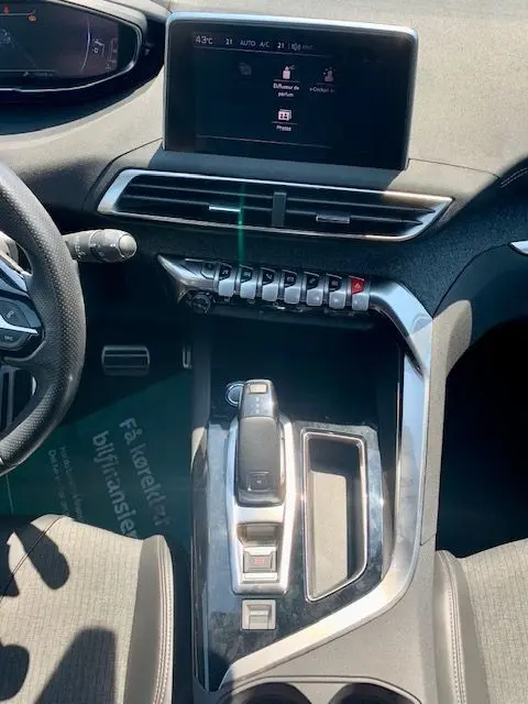 Vue intérieure centrée sur la console centrale et écran tactile du Peugeot 3008 noir, version GT Line 2018.
