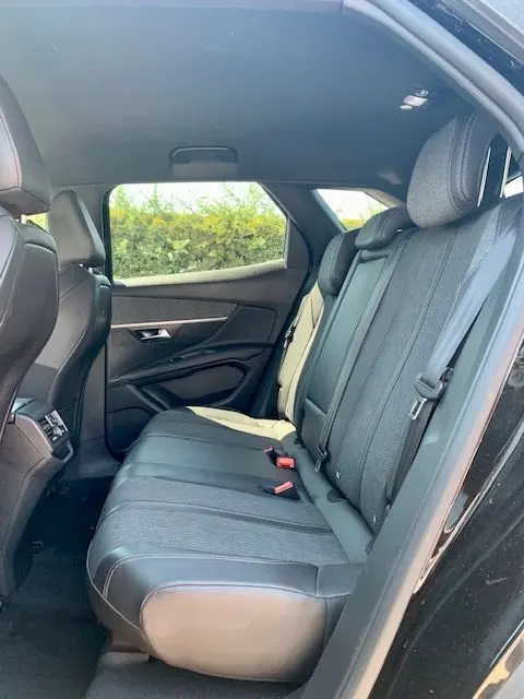 Vue intérieure arrière droite du Peugeot 3008 noir 2018, montrant les sièges arrière en tissu et cuir avec ceintures de sécurité.