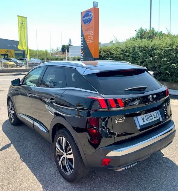 Vue 3/4 arrière droite d'un Peugeot 3008 noir 2018 GT Line avec feux arrière à griffes distinctifs et toit argenté.