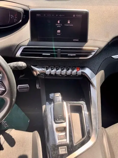 Vue intérieure de la console centrale et tableau de bord du Peugeot 3008 noir, avec écran tactile et commandes piano.