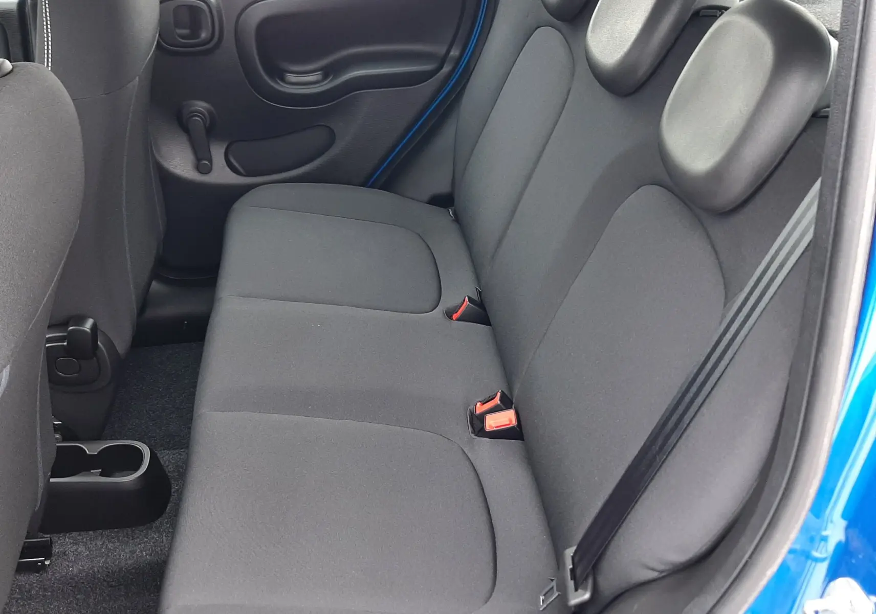 Vue intérieure côté droit des sièges arrière noirs en tissu de la Fiat Panda bleu Italia 2025 à cinq portes.