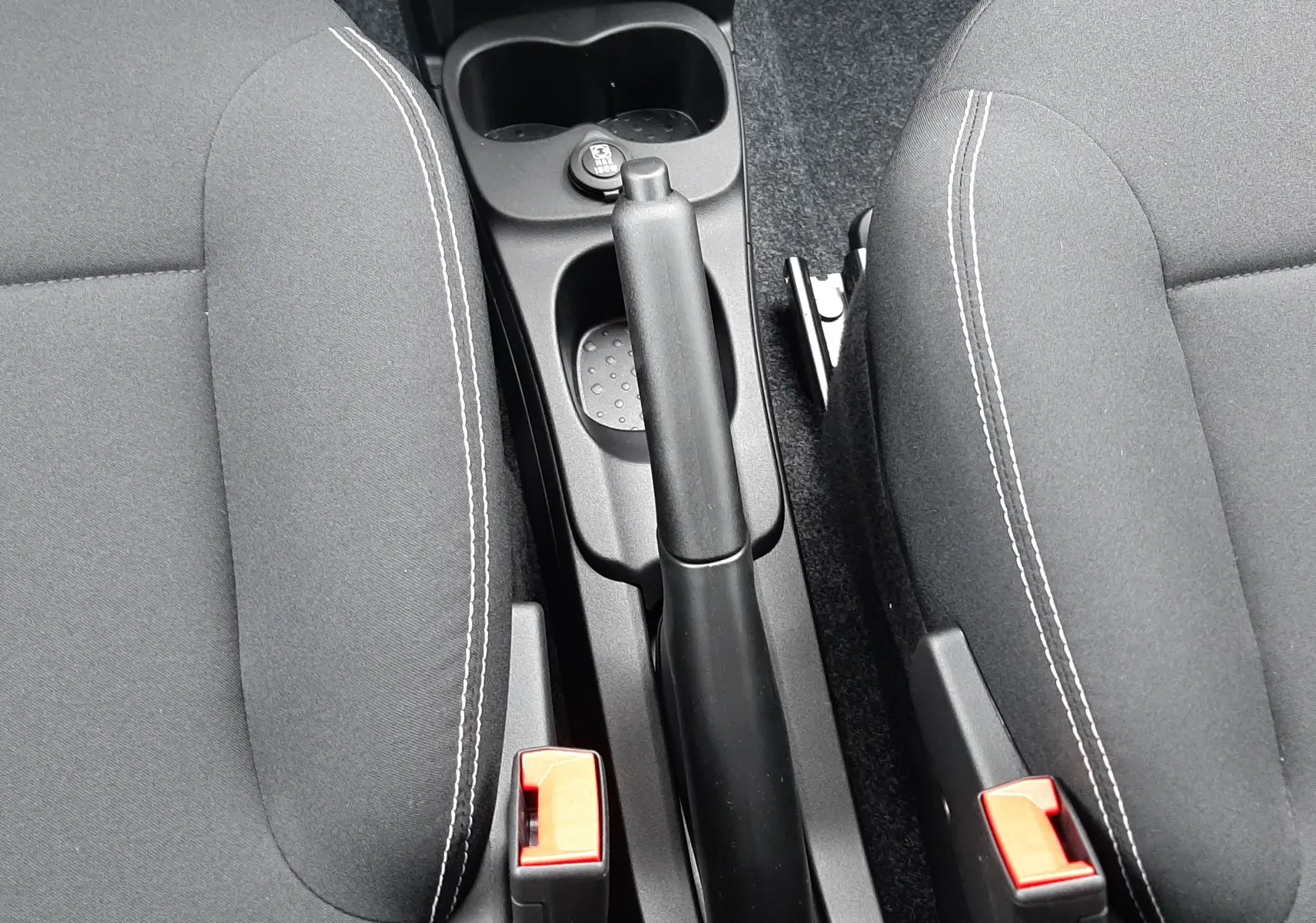 Vue plongeante sur la console centrale et les sièges noirs en tissu de la Fiat Panda 2025 Bleu Italia.