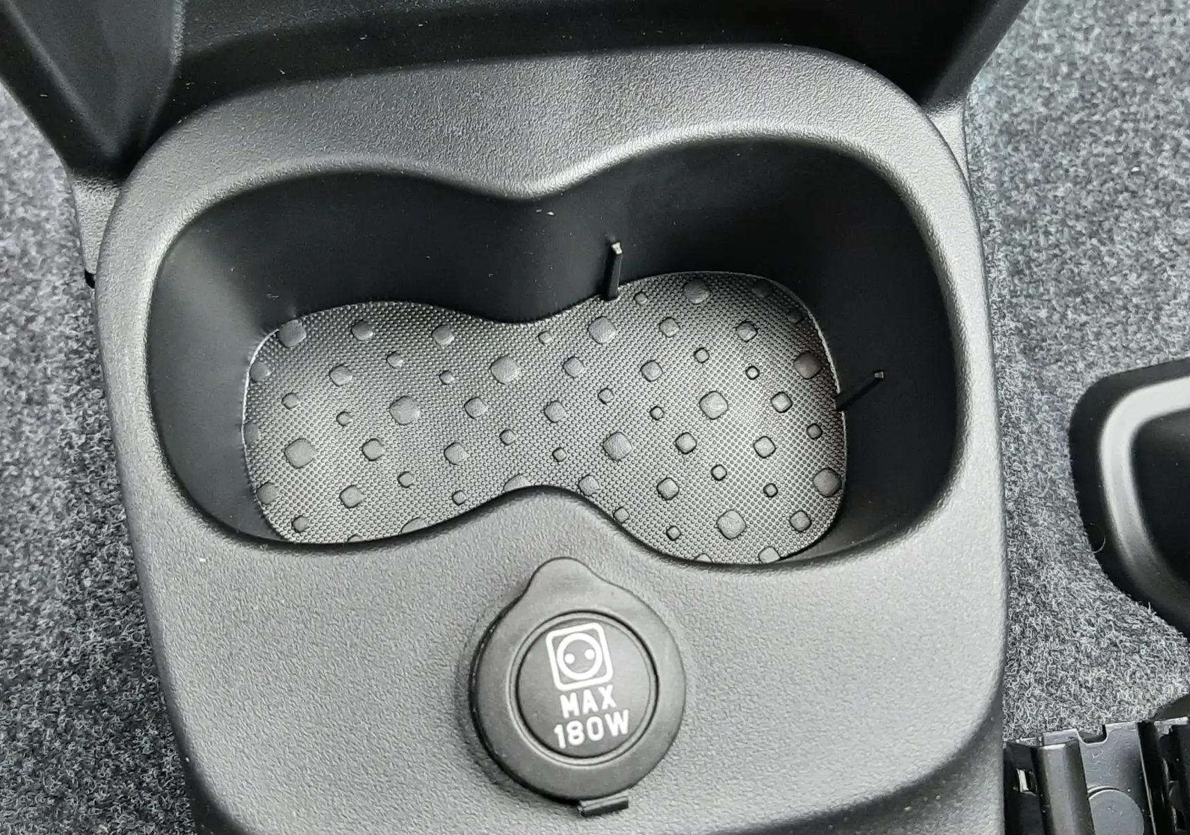 Gros plan sur le porte-gobelets central noir avec prise 12V 180W de la Fiat Panda 2025 Bleu Italia.