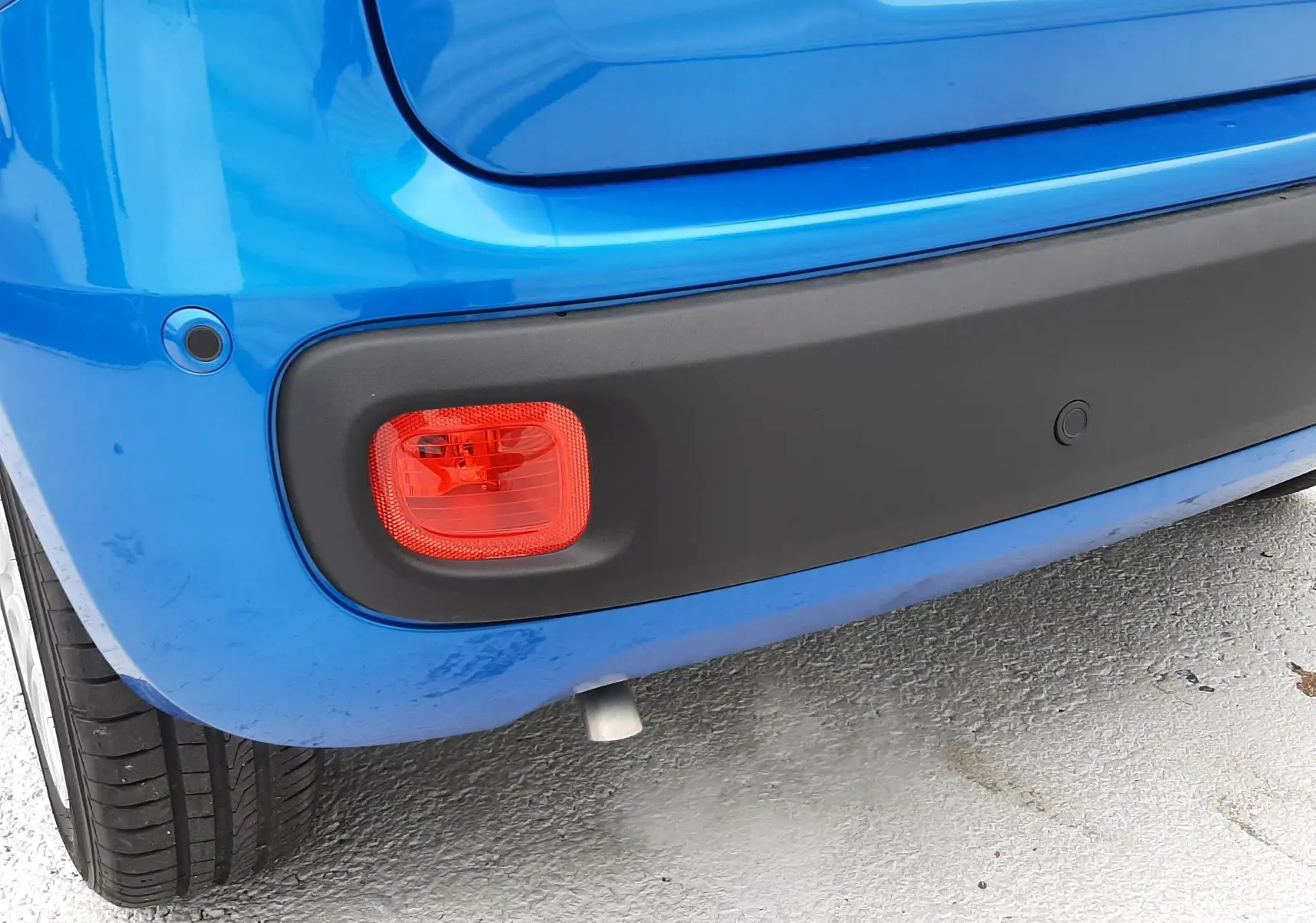 Gros plan sur le coin arrière gauche bleu Italia d'une Fiat Panda 2025 avec feu rouge et pare-chocs noir mat.