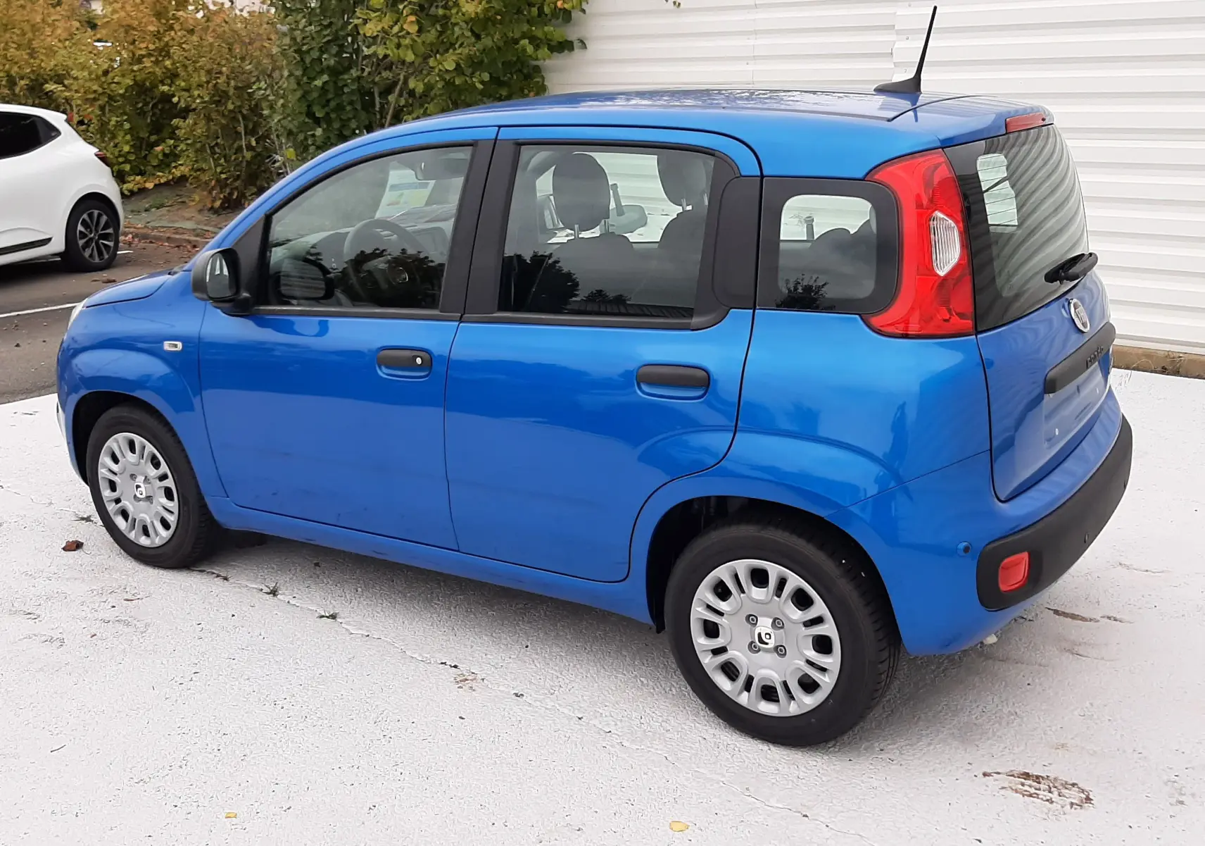 Vue 3/4 arrière côté droit d'une Fiat Panda 2025 bleu Italia, compacte avec cinq portes et feux arrière rouges distinctifs.
