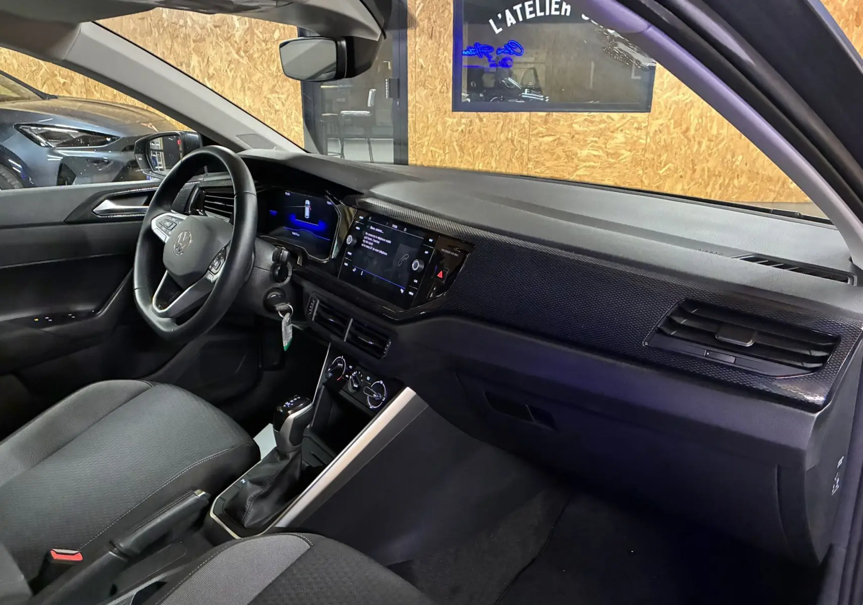 Intérieur côté conducteur de la Volkswagen Polo gris 2025, tableau de bord moderne avec écran tactile et volant multifonction.