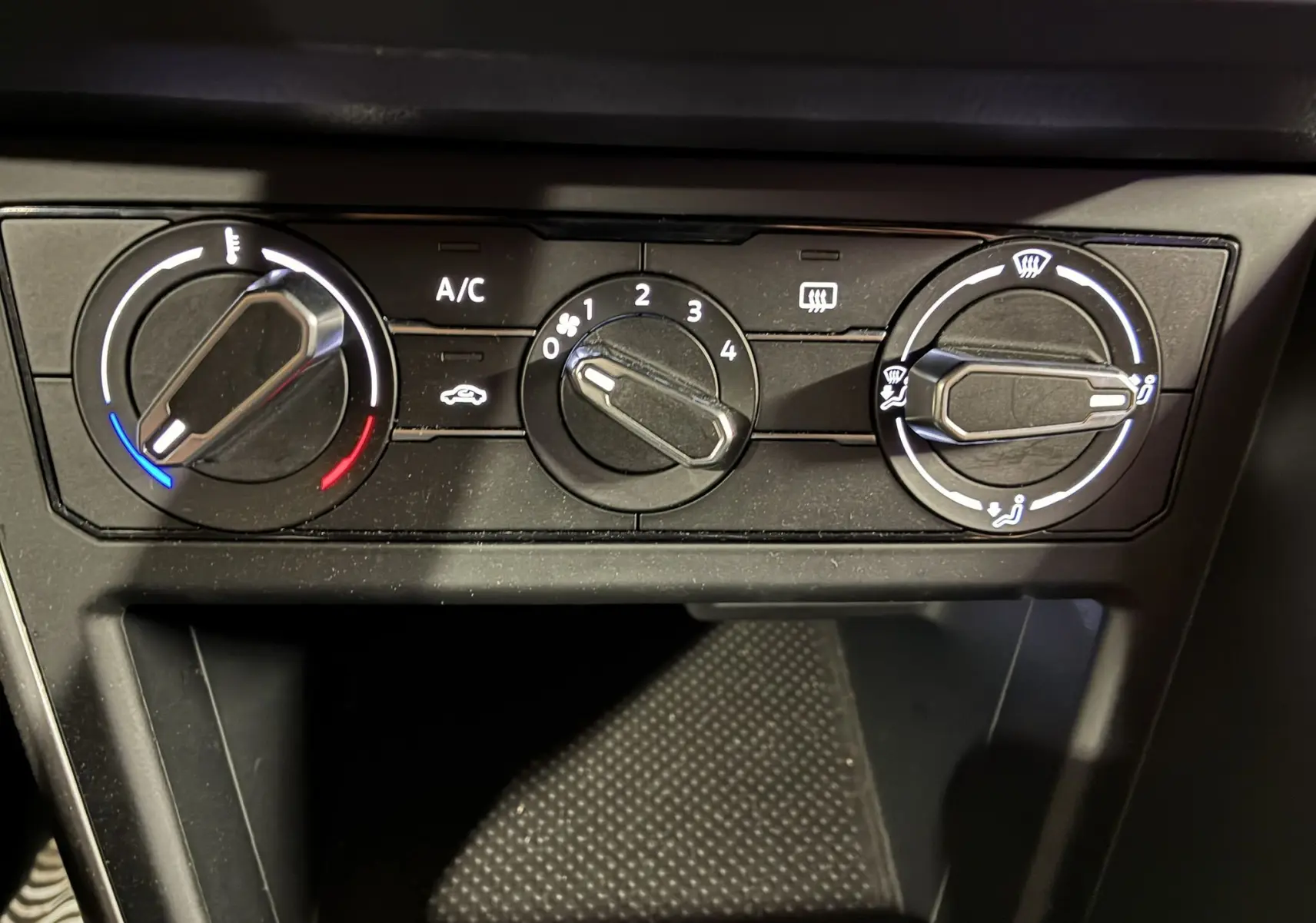 Commandes de climatisation noires en gros plan dans l'habitacle d'une Volkswagen Polo gris 2025, version Edition 50.